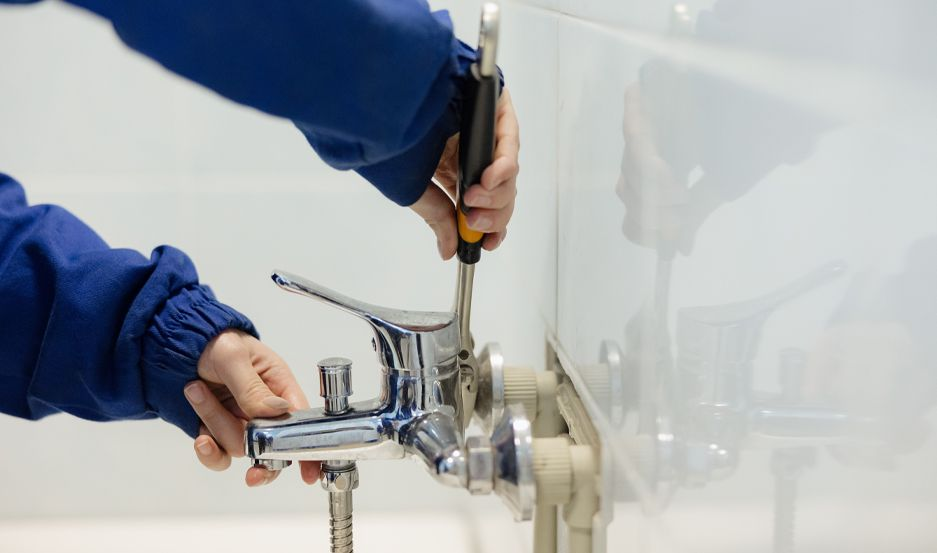 Plumber installing a bathroom faucet fixture in a Franklin County PA home