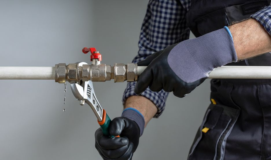 Plumber replacing aging galvanized water lines during a repiping job